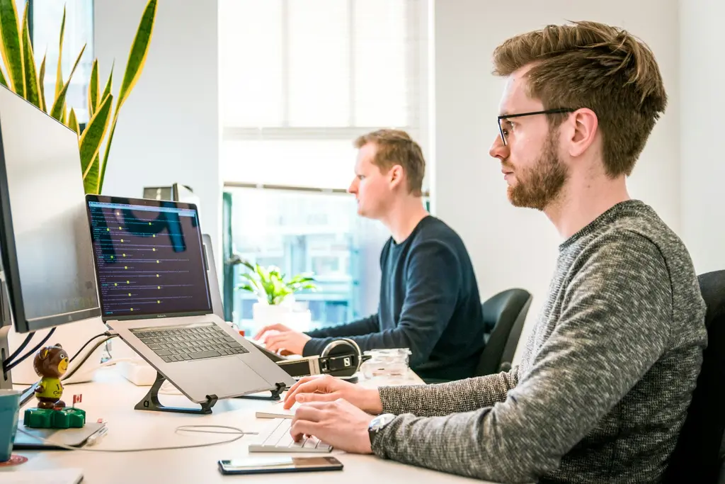 Two developers working at computer screens in a bright office