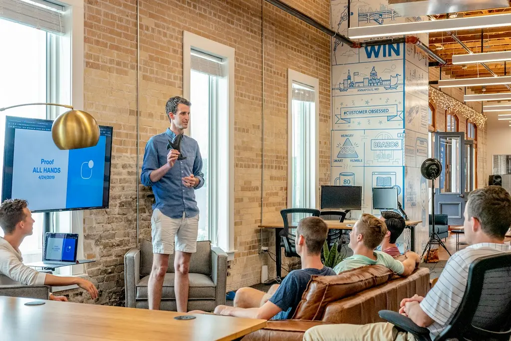 A speaker presenting to colleagues in a bright, informal office space