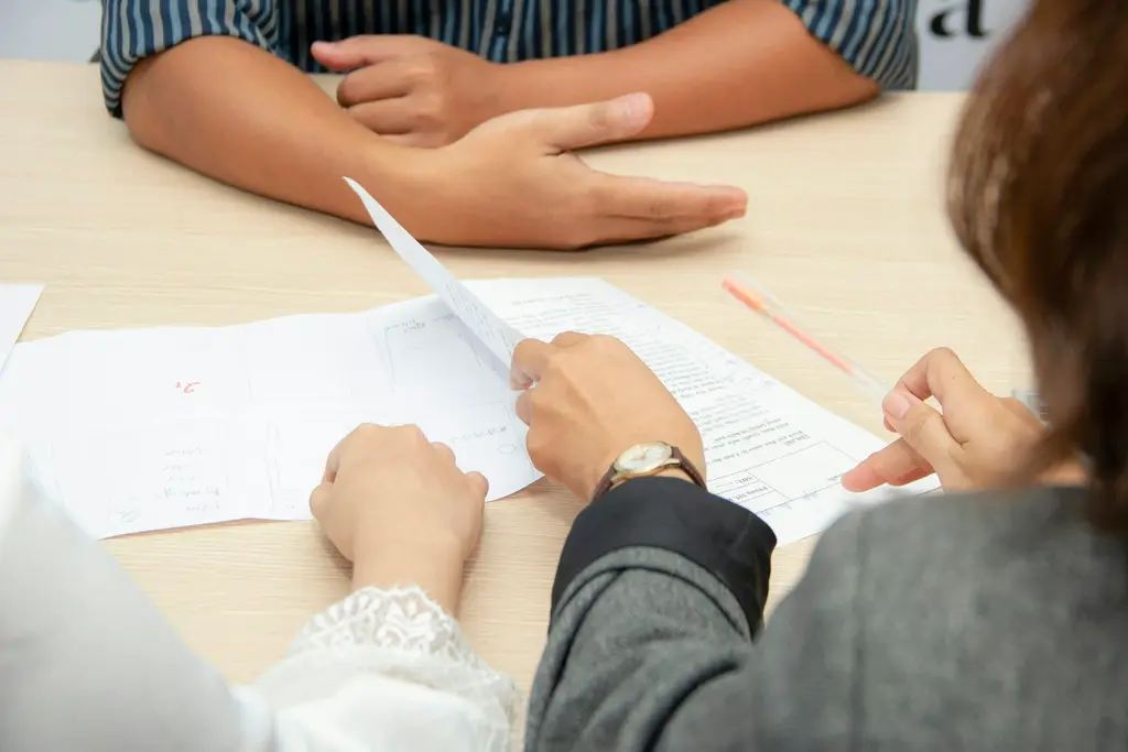 Two people discussing a document across a desk during an interview
