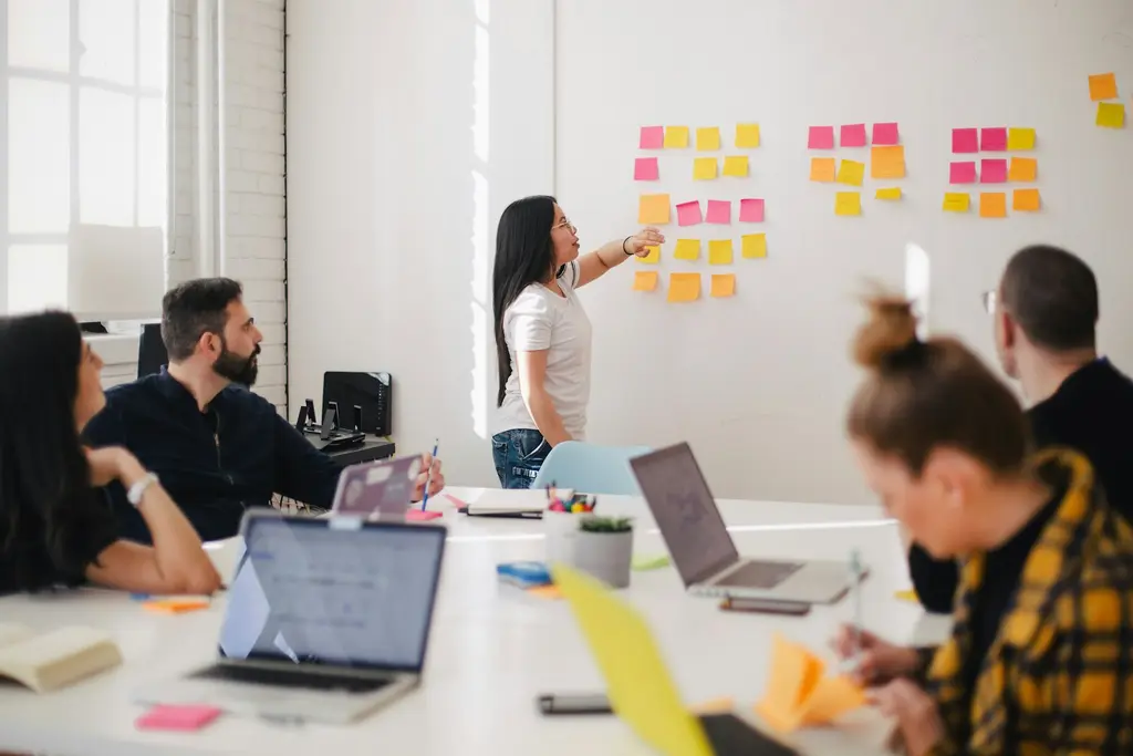 A team planning work together using sticky notes on a whiteboard