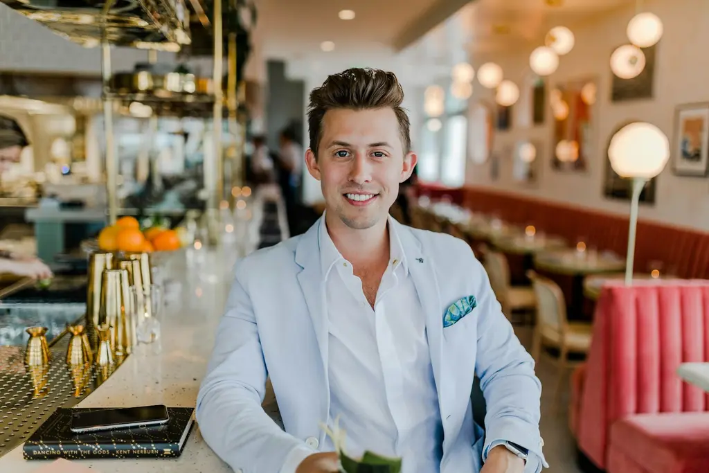 A smiling professional in a blazer seated in a modern venue